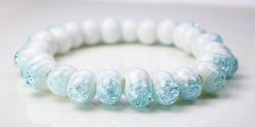 Unusual shaped white glass bead drop shaped with sky blue cracked crystal ending on stretched ribbon lady bracelet